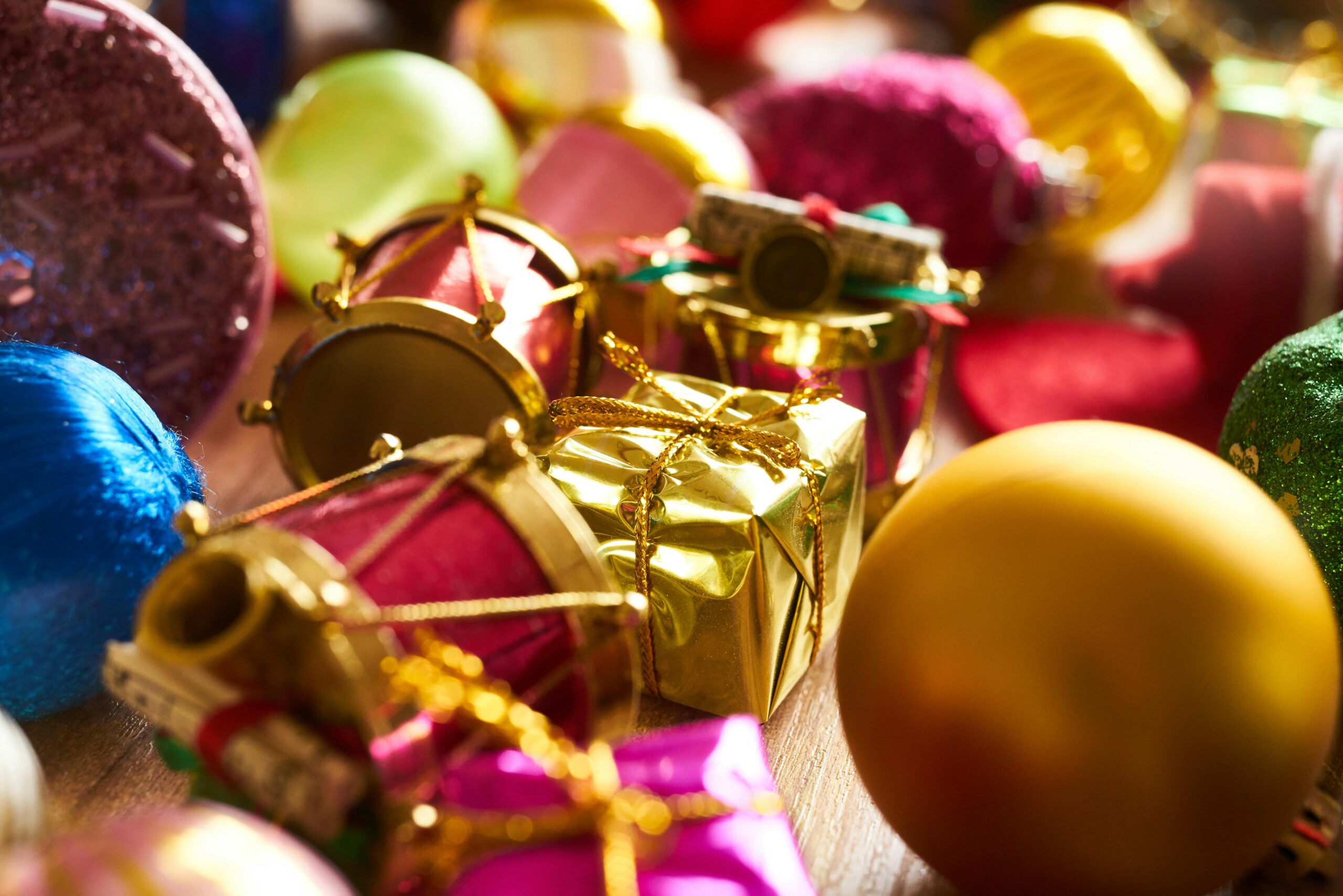 Colorful display of Christmas decorations featuring gift boxes, drums, and baubles.